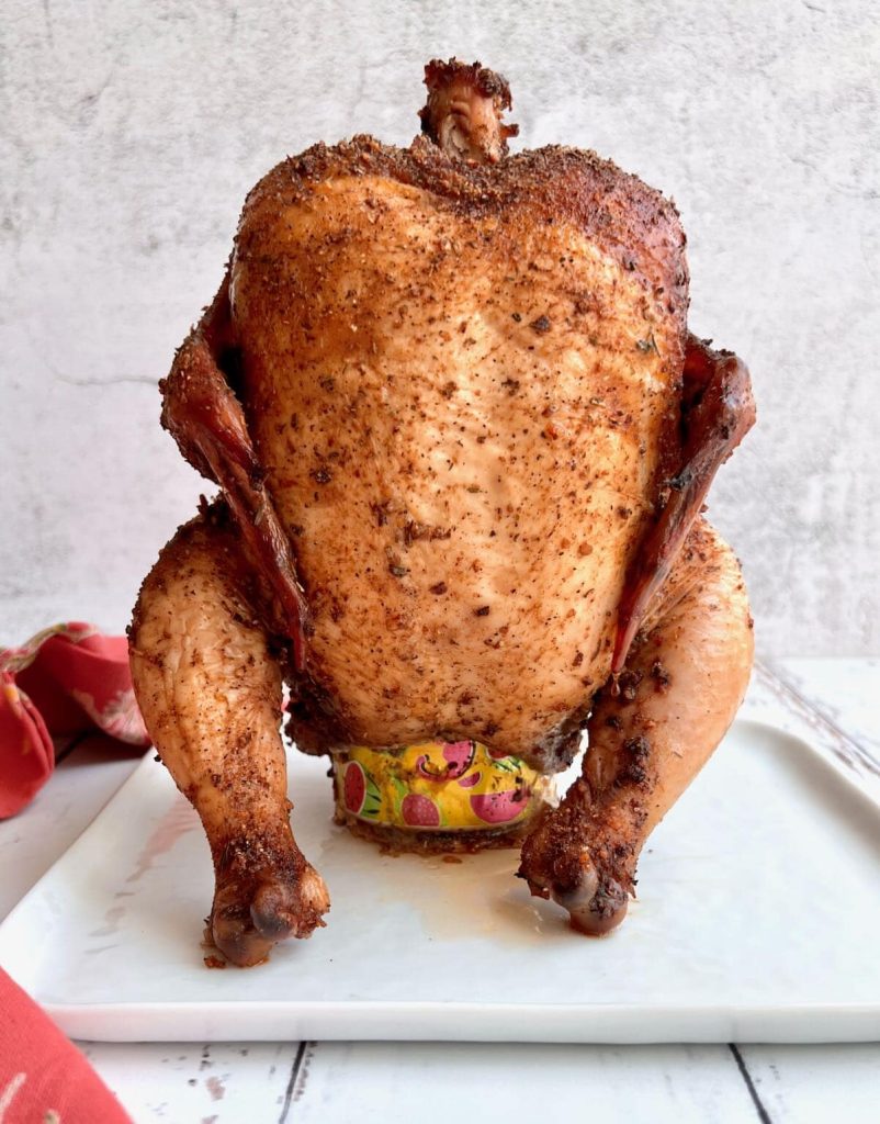 golden brown cooked whole chicken with bear can
