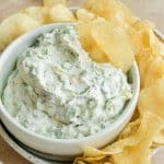 cottage cheese dip in a white bowl with potato chips around