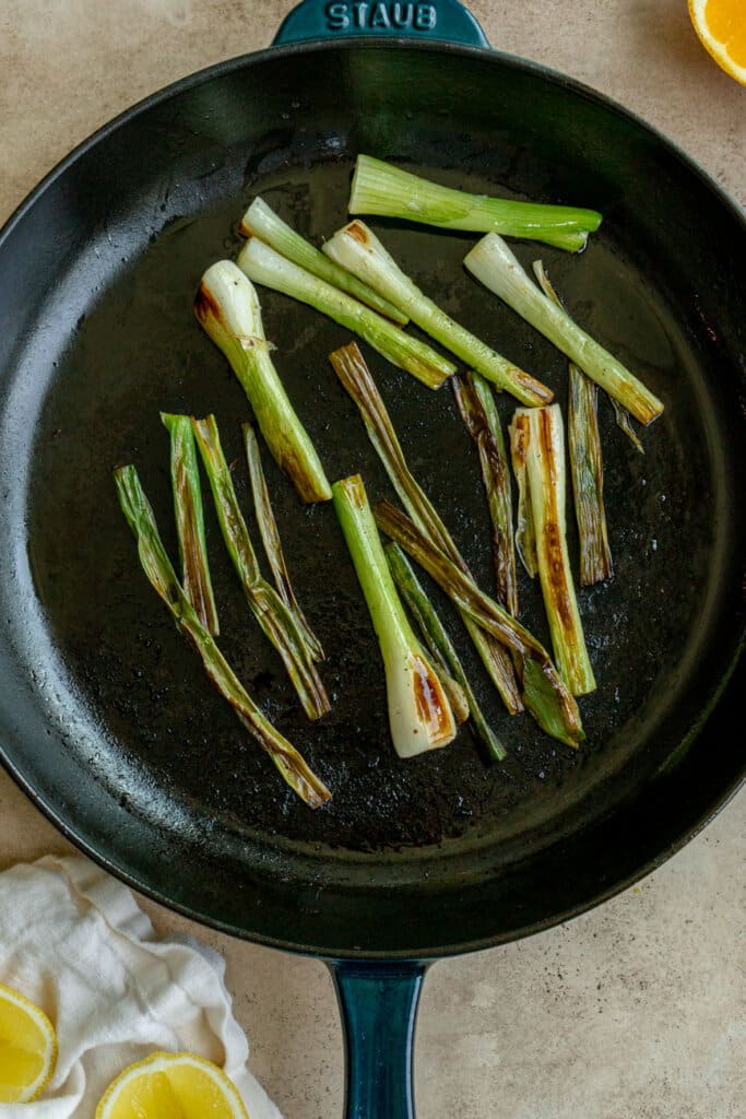 a cast iron pan with charred scallions.