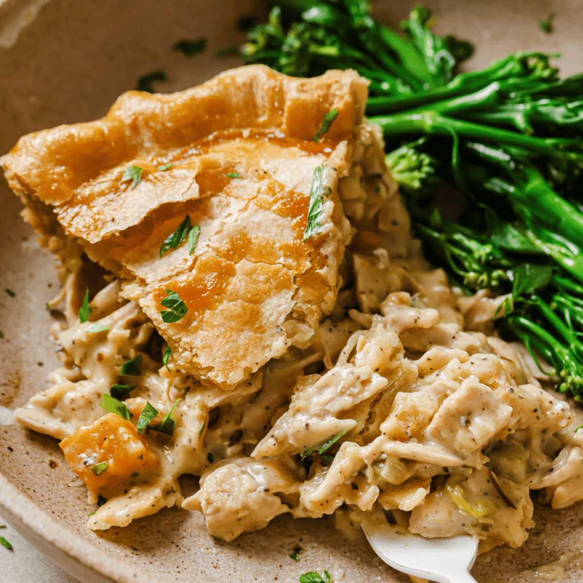 thanksgiving leftover pot pie on a plate with broccolini