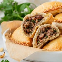 air fryer beef empanadas piled up on a white dish