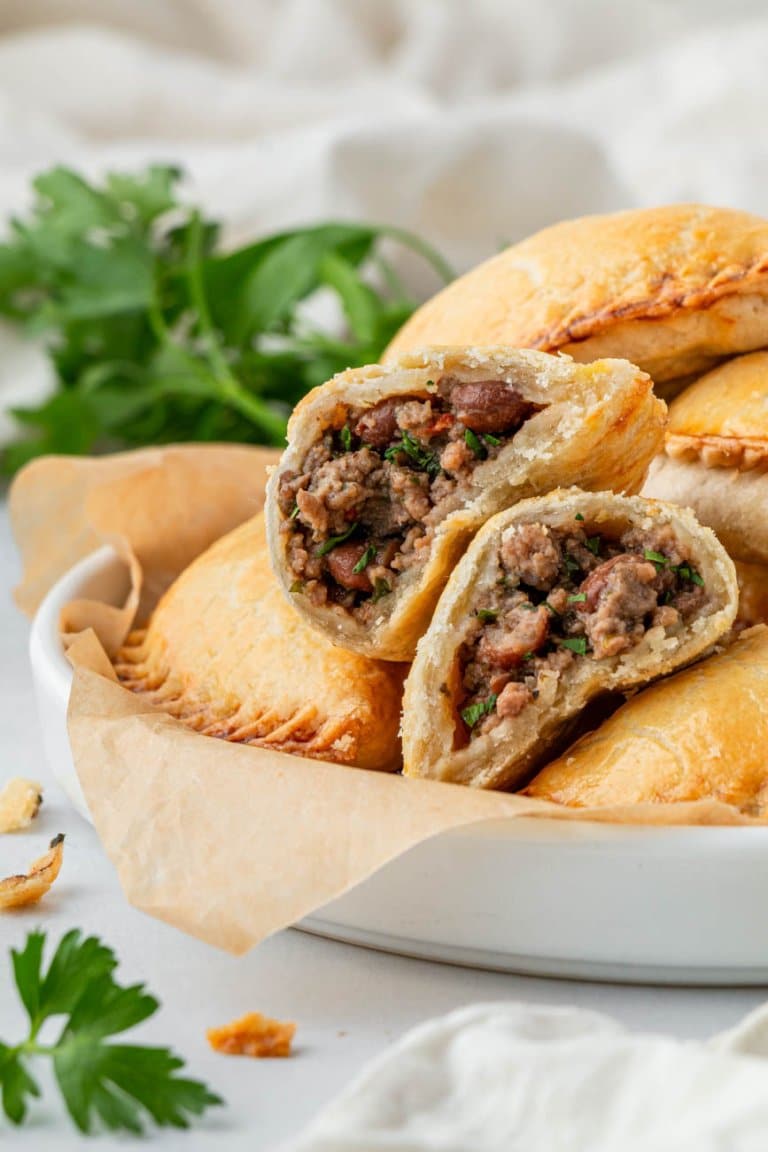 air fryer beef empanadas piled up on a white dish