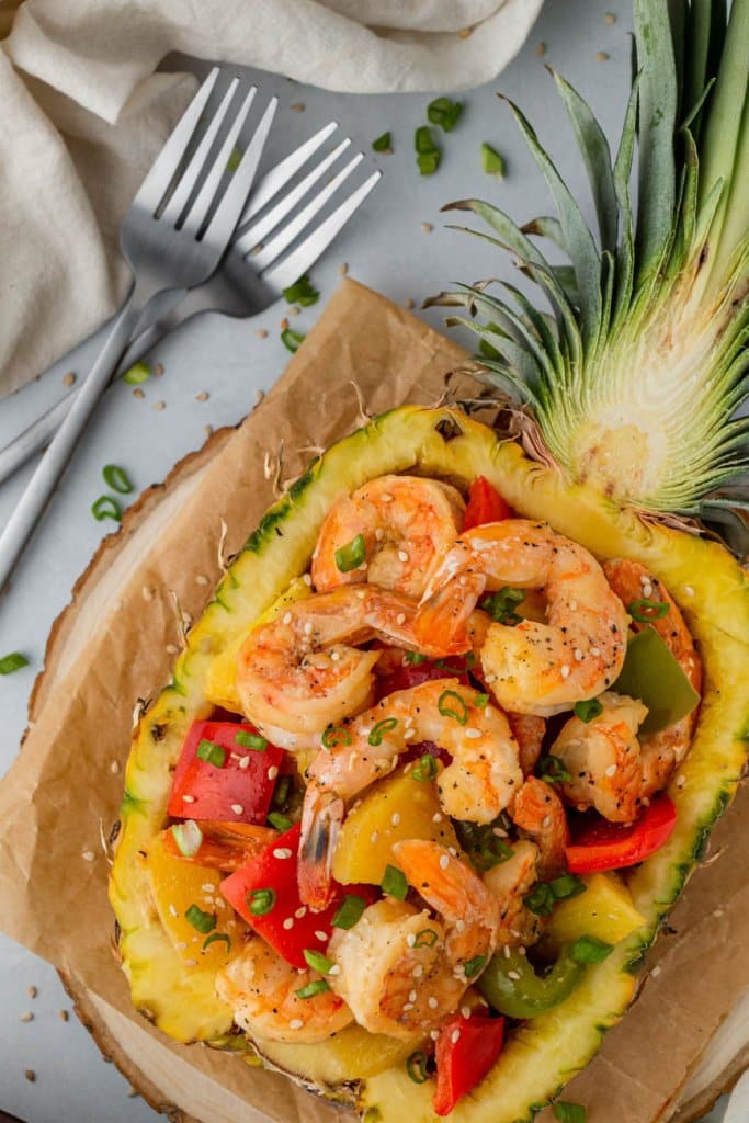 chinese pineapple shrimp in a pineapple with two forks on the side