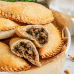 air fryer beef empanadas on a white plate with brown parchment paper