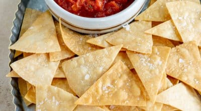 air fryer tortilla chips on a serving platter with salsa in a small bowl