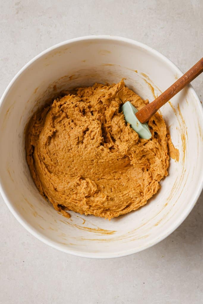 pumpkin mixture in a mixing bowl with a spatula