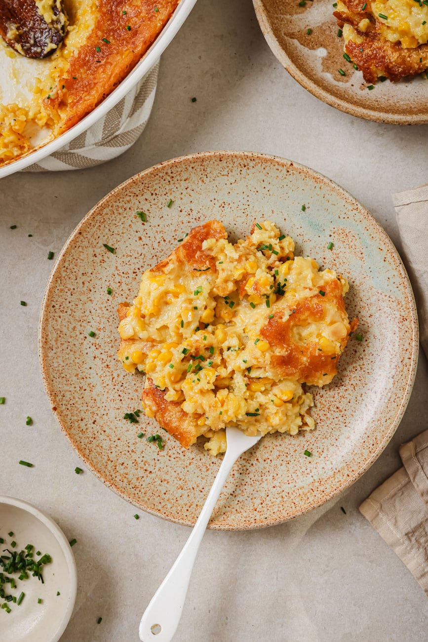 baked corn casserole served on a plate with a silver fork