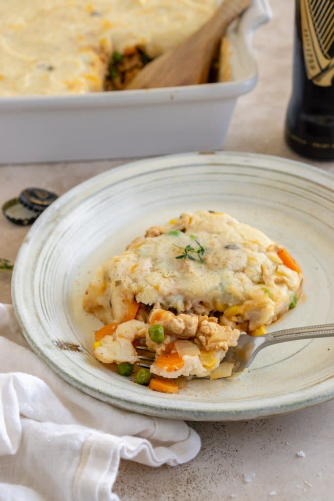 close up of a piece of ground turkey shepherd's pie on a plate with a fork taking a bite