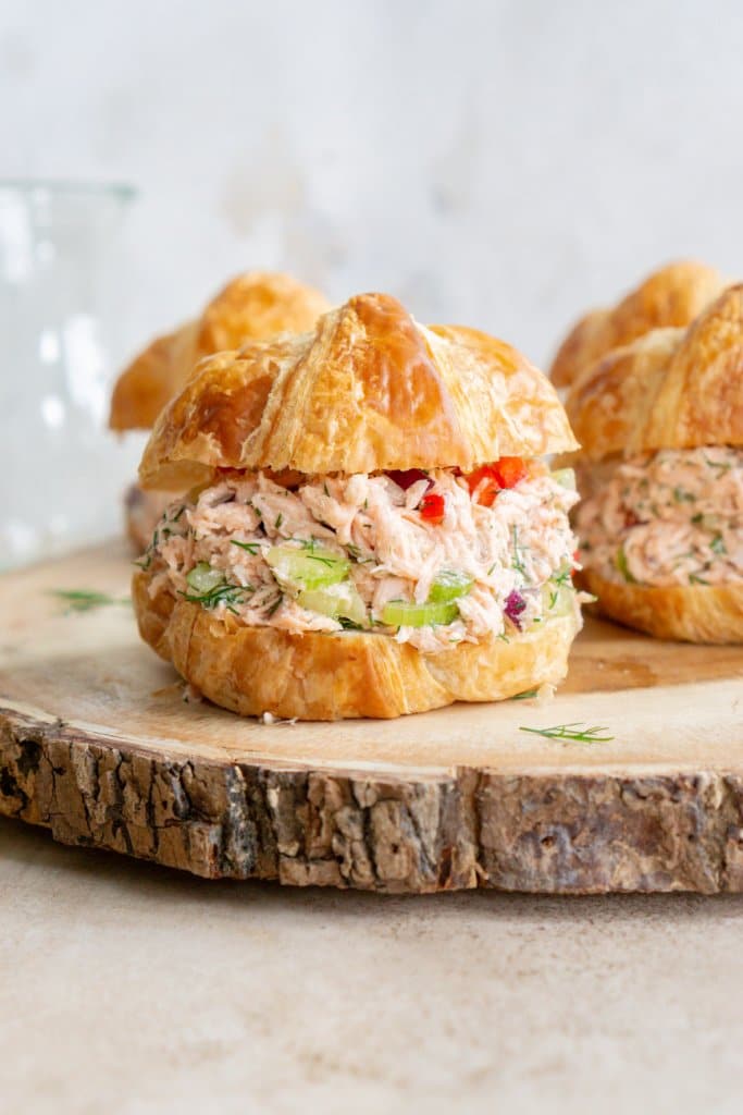 salmon salad sandwiches on a wood serving tray