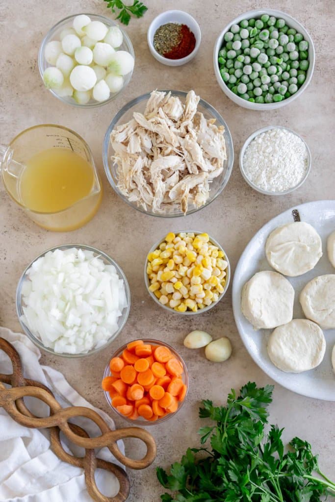 shredded turkey, carrots, onions, corn, chicken broth, biscuits, and peas in small ingredient bowls