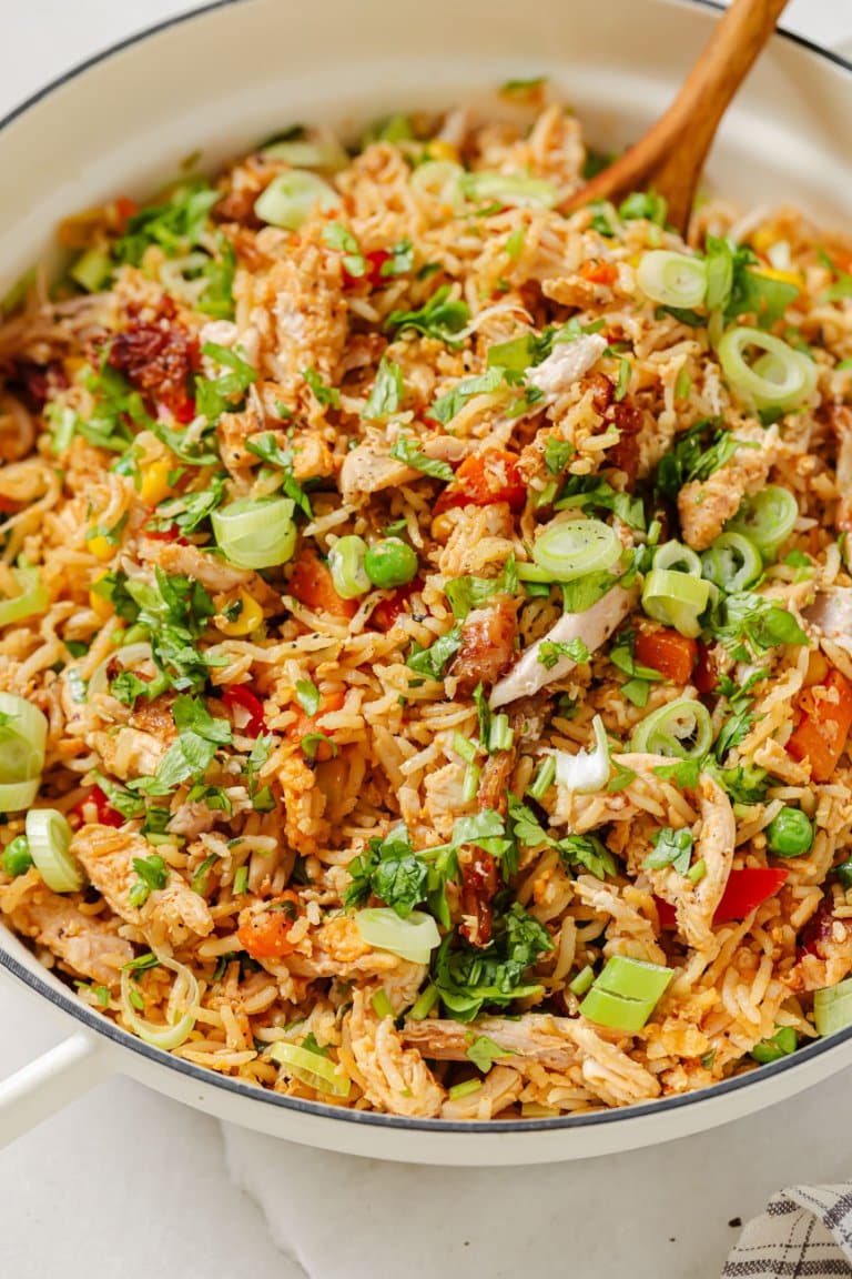 leftover turkey fried rice in a white pot with a wooden spoon