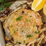roasted cabbage steak on a sheet pan with lemon wedges and parsley