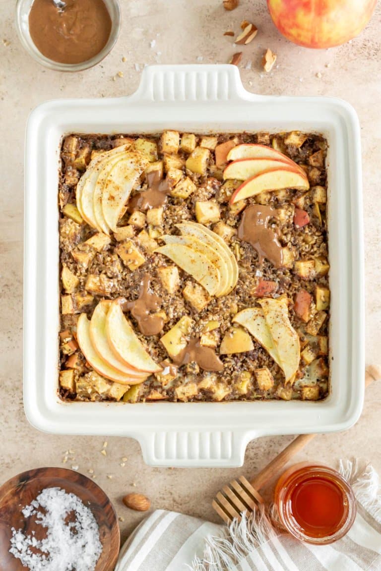 baked apple cinnamon oatmeal in a serving dish with almond butter, salt, and honey on the side