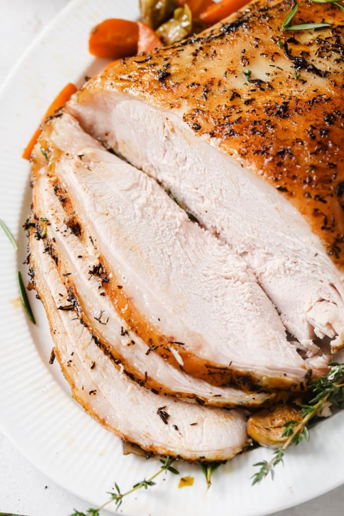 slow cooker turkey breast sliced on a white serving platter