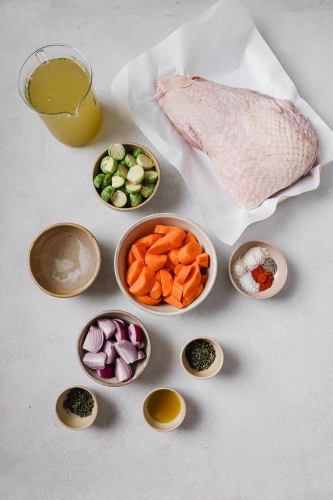 turkey breast, olive oil, carrots, red onion, brussels sprouts, and spices in small ingredient bowls