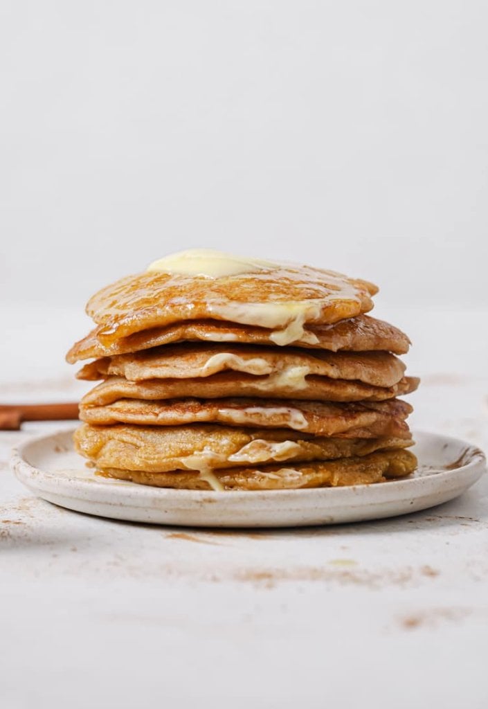 a stack of spiced apple pancakes on a white plate