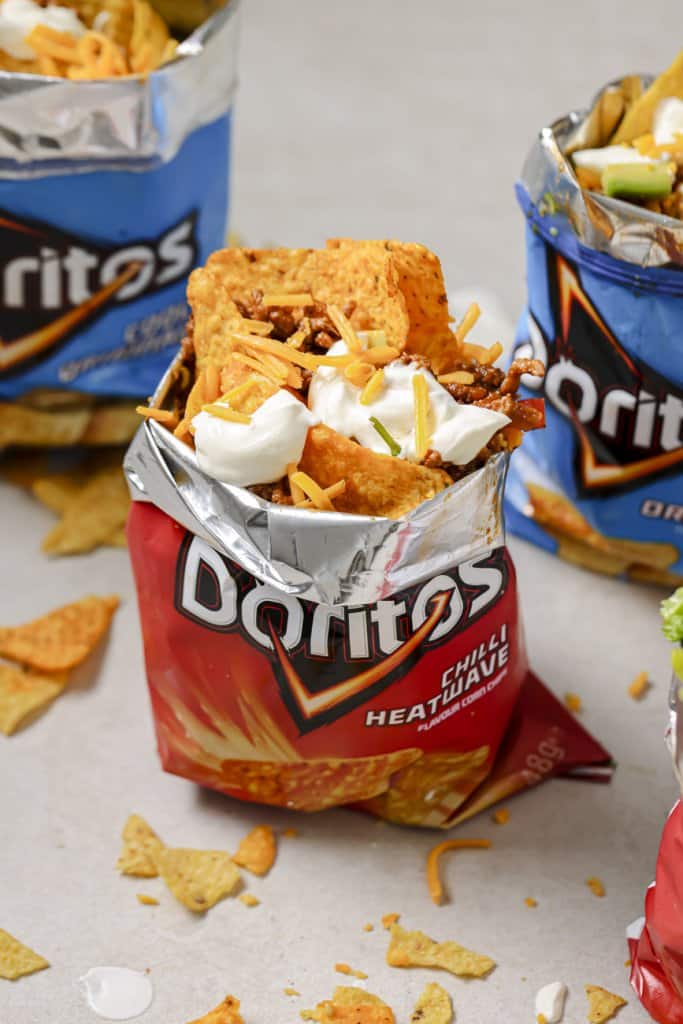 three doritos walking taco bags with chips scattered around