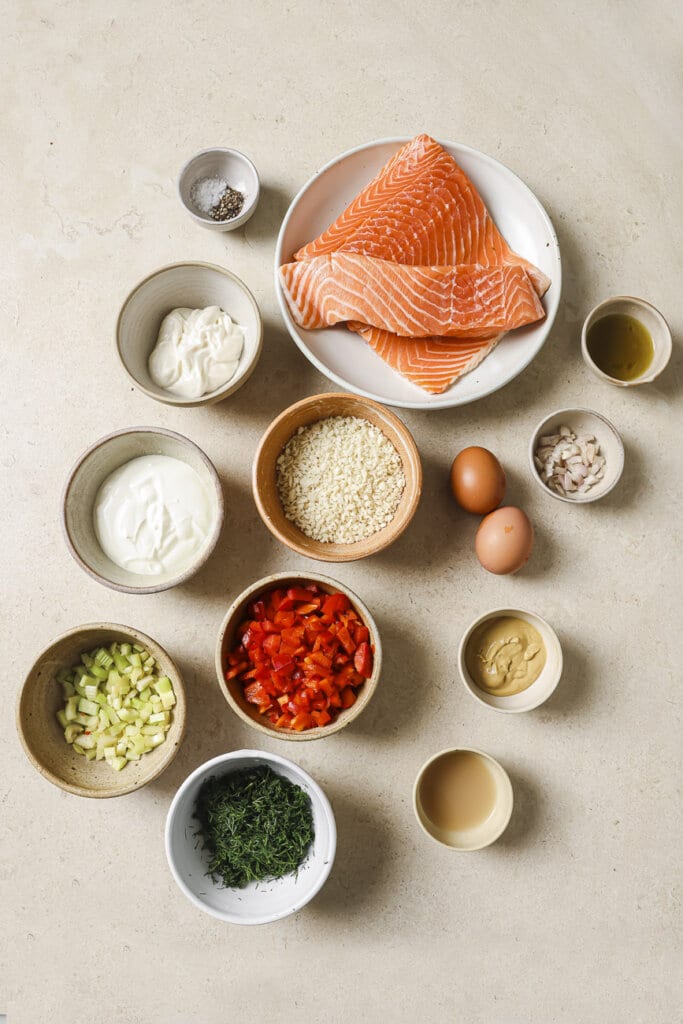 salmon, red peppers, celery, dill, eggs, mayonnaise, and spices in small ingredient bowls