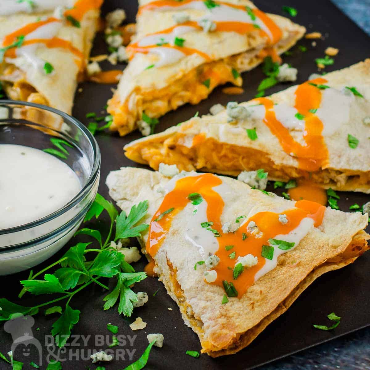 buffalo chicken quesadillas on a plate with ranch dressing in a cup