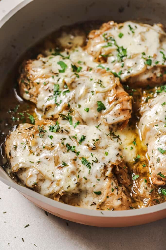 french onion chicken in a pan with parsley on top