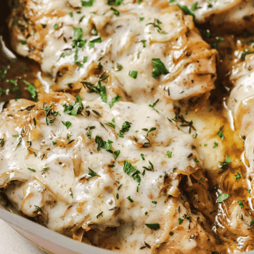 french onion chicken in a pan with parsley on top