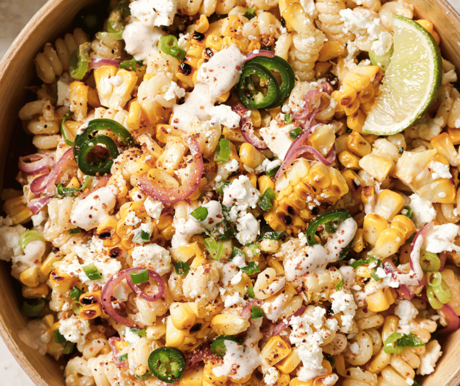 mexican street corn pasta salad in a bowl with a lime wedge