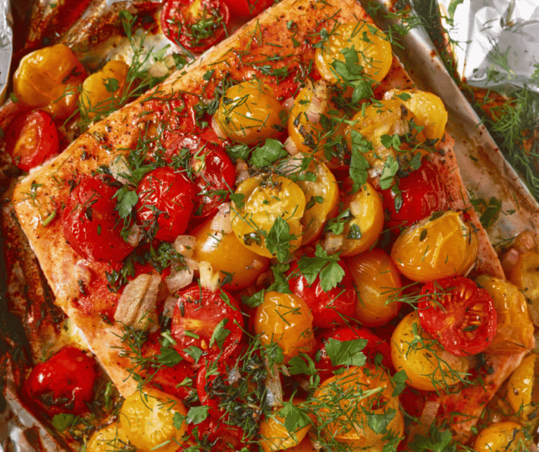 Close up view of foil baked salmon with cherry tomatoes.