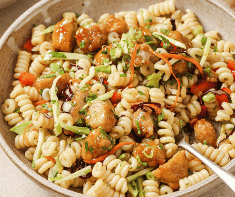 Close up view of orange chicken pasta salad.