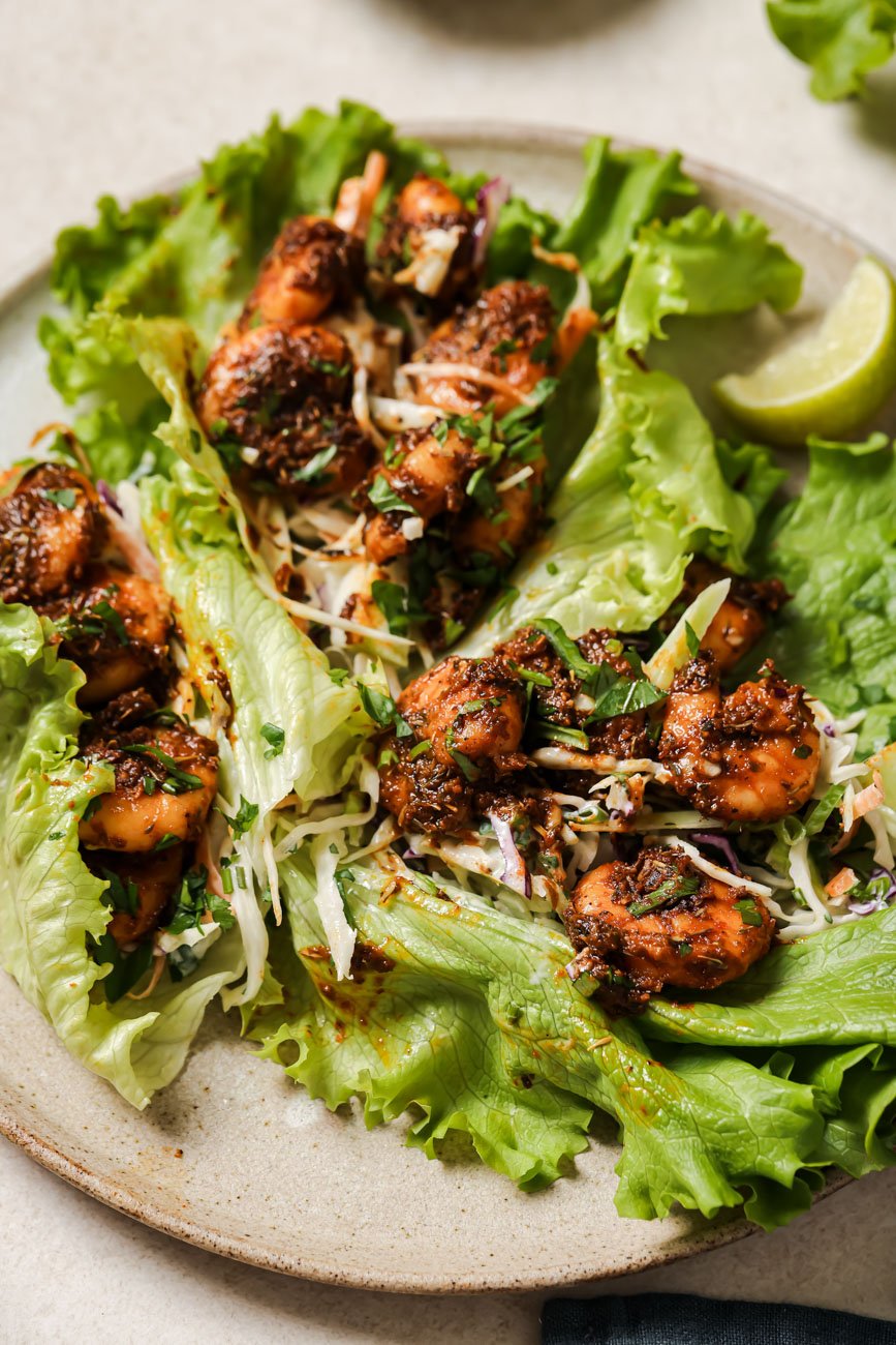 A plate with lettuce wraps filled with blackened shrimp.