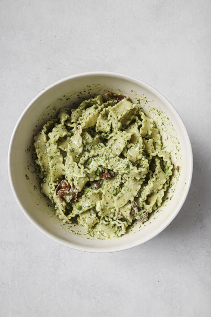 Pasta in a bowl tossed with pesto.