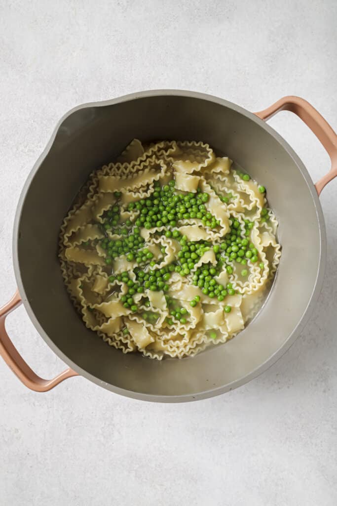 Pasta and peas cooking in hot water.