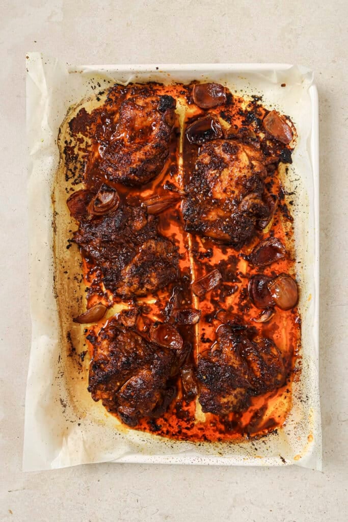 Baked chicken thighs on a baking sheet.