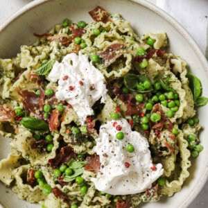 Closeup overhead shot of a bowl of pesto prosciutto pasta.