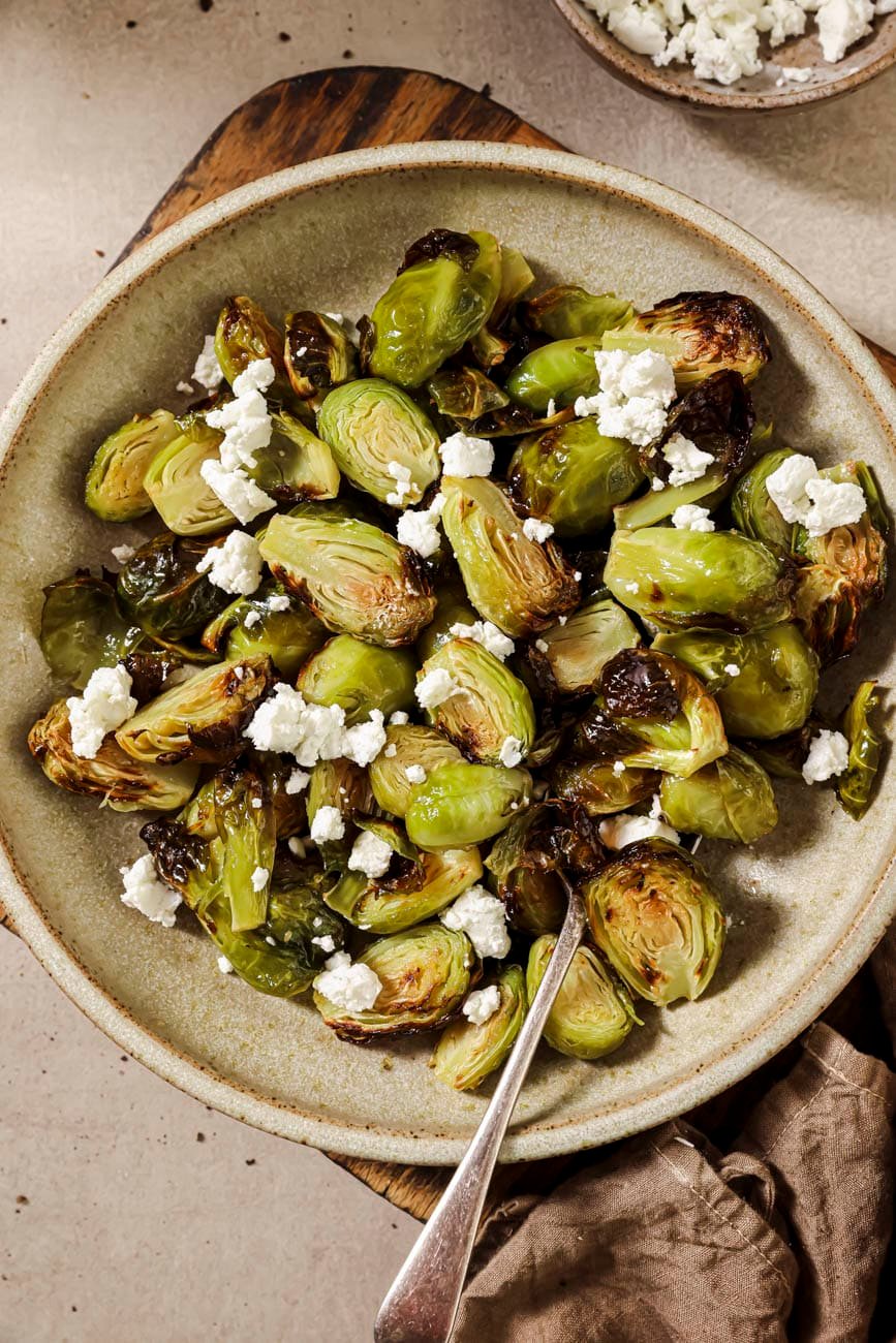 Top down view of a plate of air fried brussels sprouts with maple syrup.