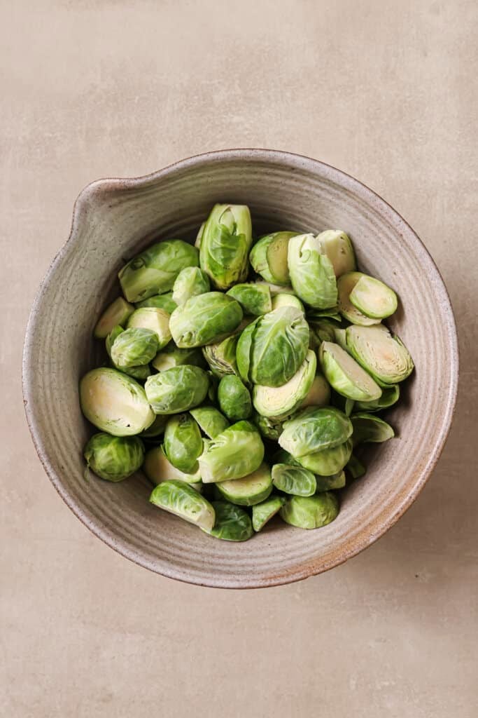 A bowl of halved brussels sprouts.