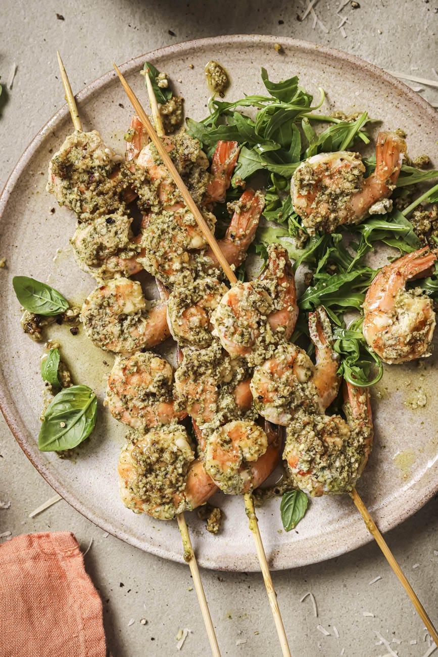 Top down view of grilled pesto shrimp on a plate.