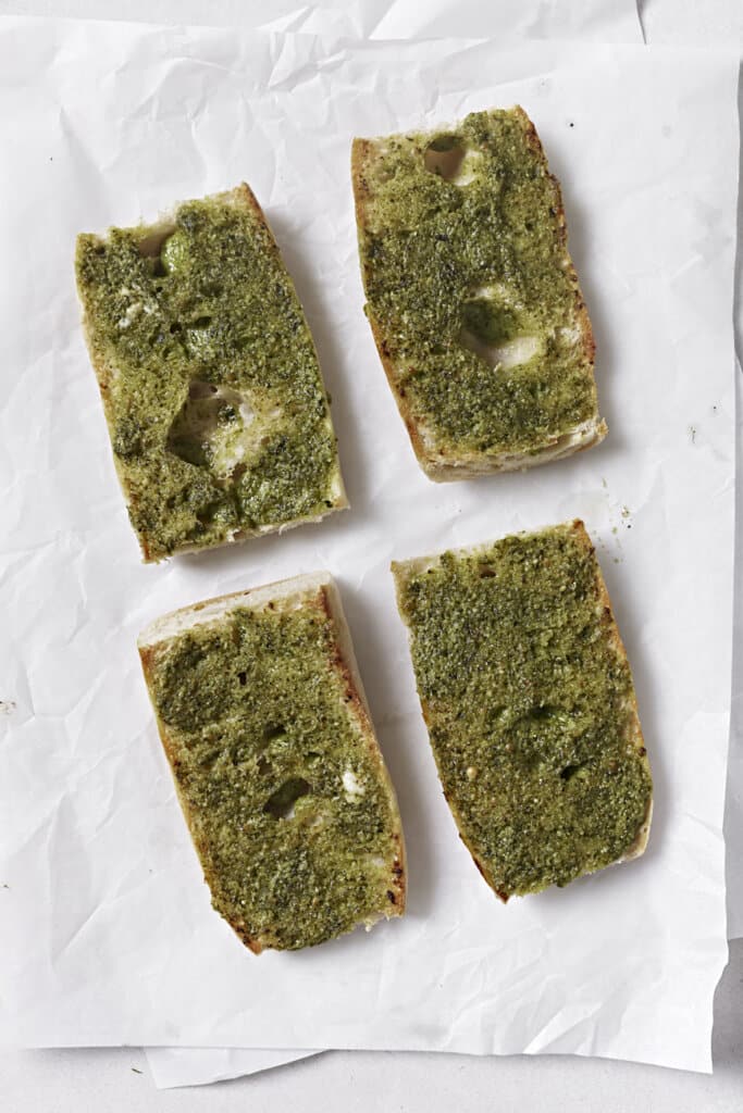 Spreading pesto on ciabatta bread.