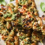 grilled pesto shrimp on wooden skewers close up photo.