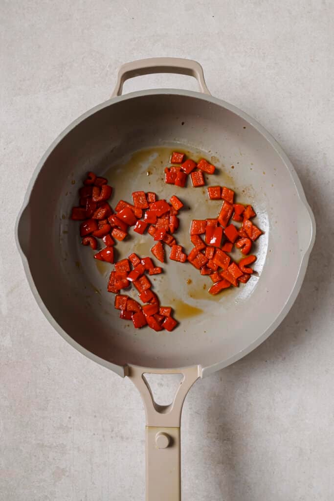 Sauteeing bell peppers in a skillet.