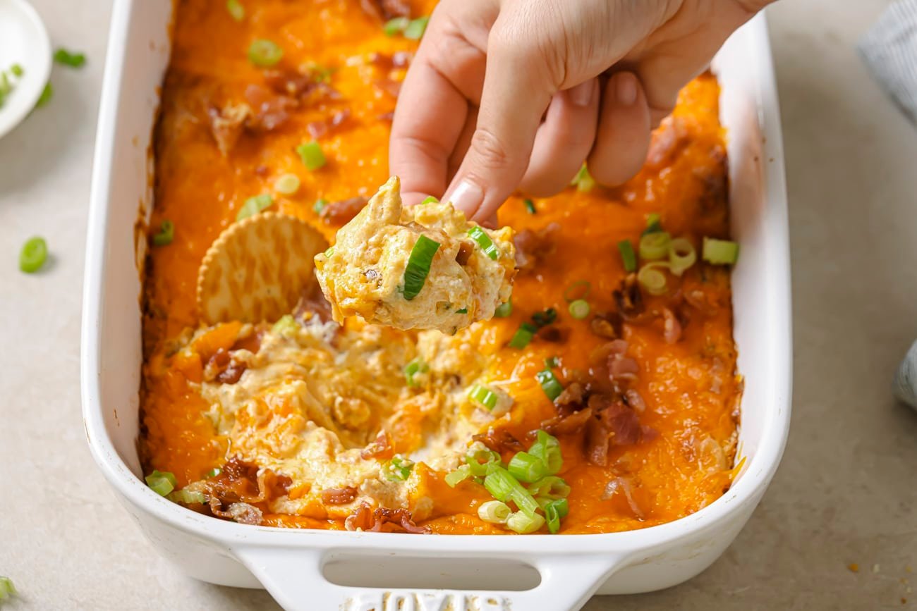 crack chicken dip with crackers dipped in it.