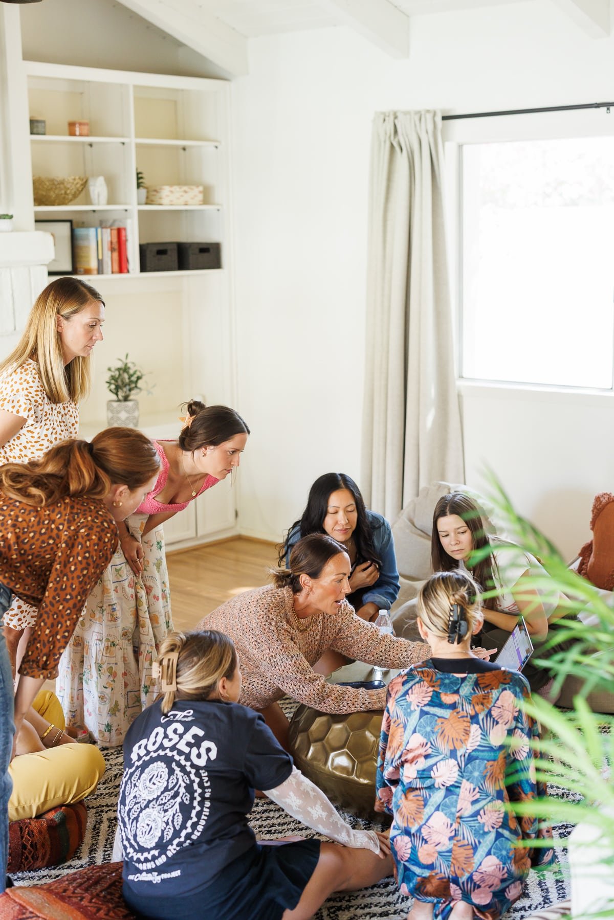 a group of women sitting around a computer.