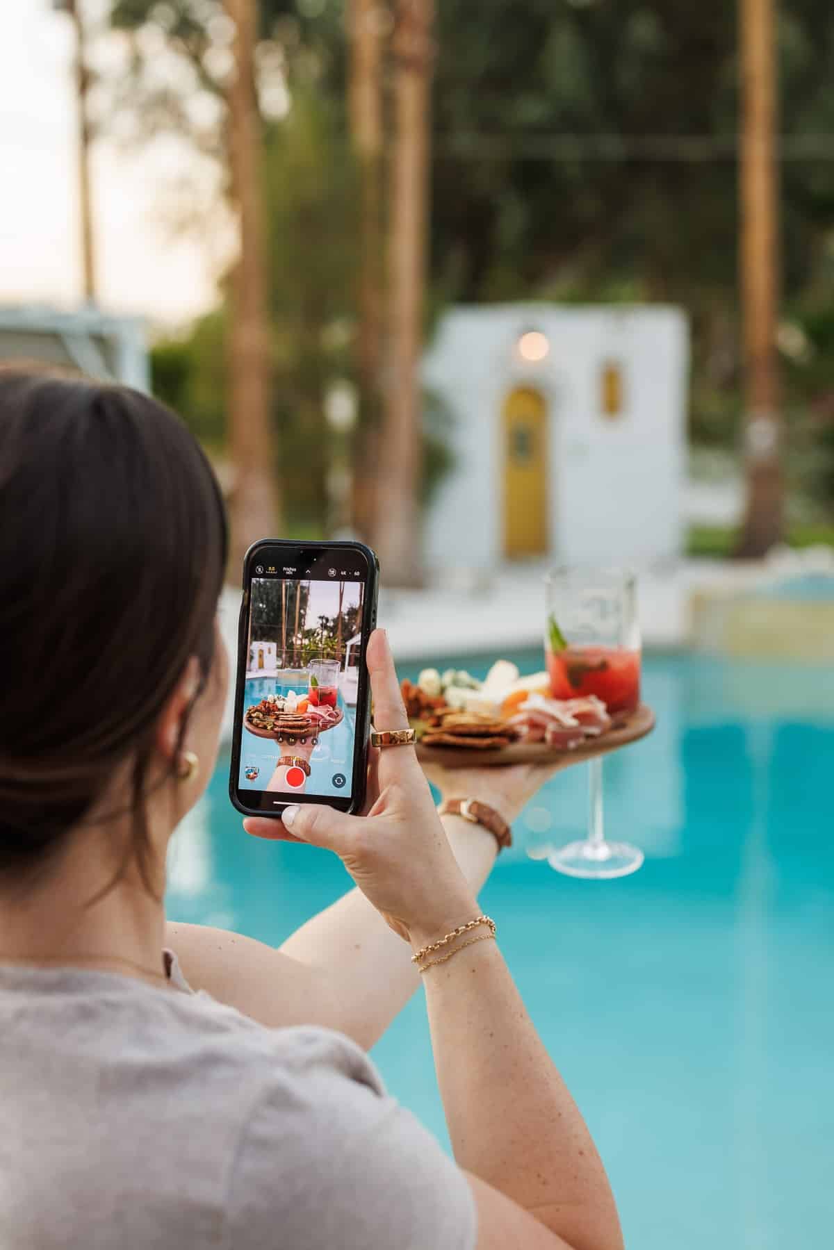 a girl holding a cheese plate and taking a photo.