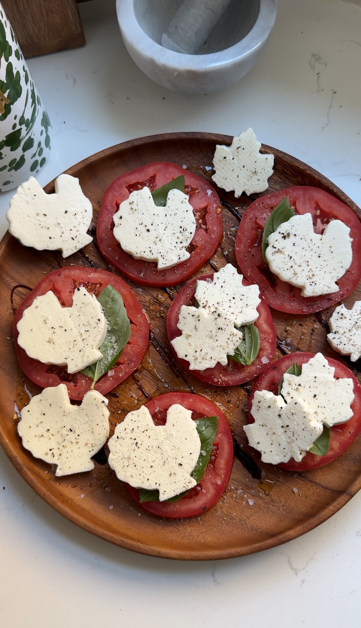 Thanksgiving caprese salad on a wood plate.