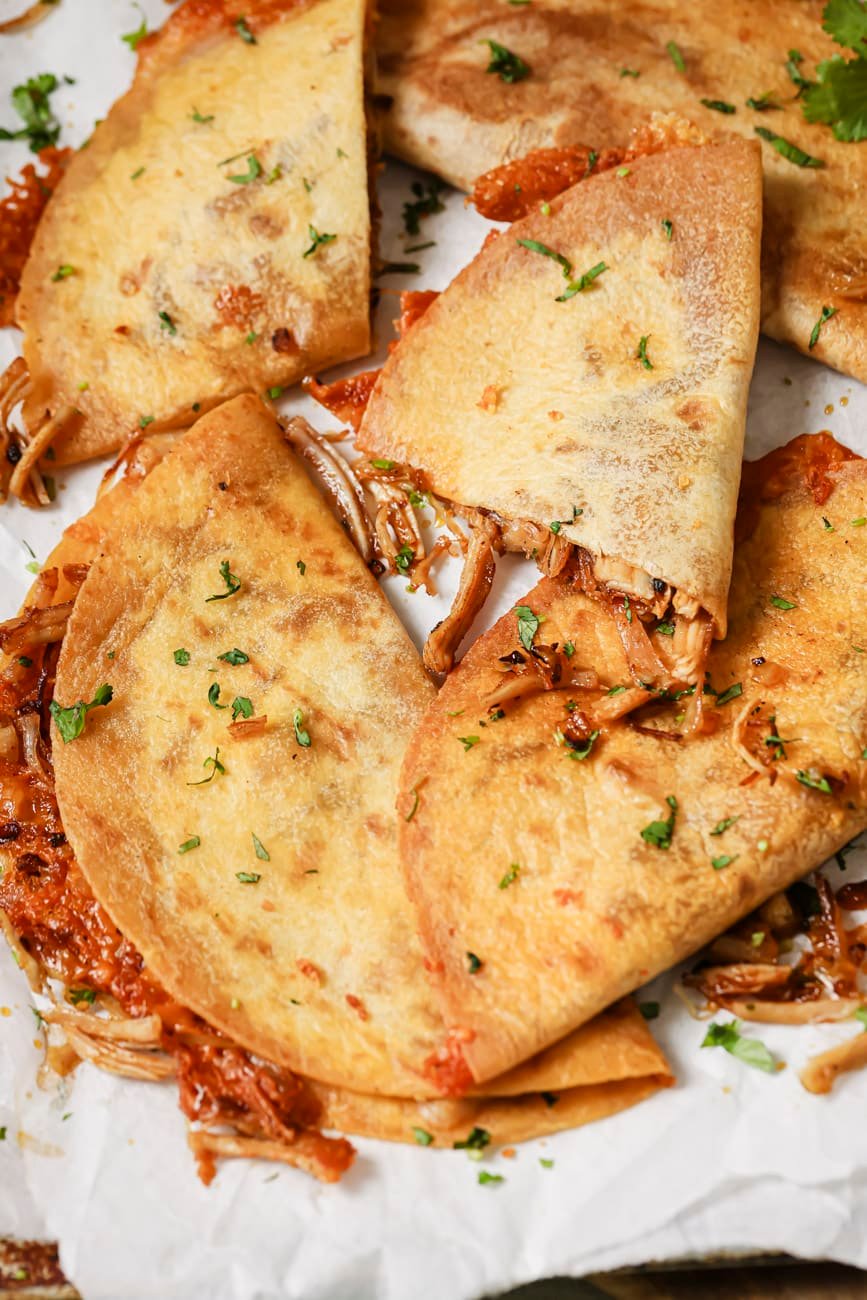 Whole and sliced leftover turkey quesadillas with cilantro on top.