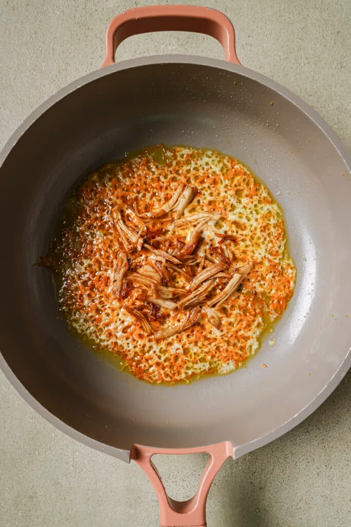 Cooking cheese and turkey in a skillet with oil.