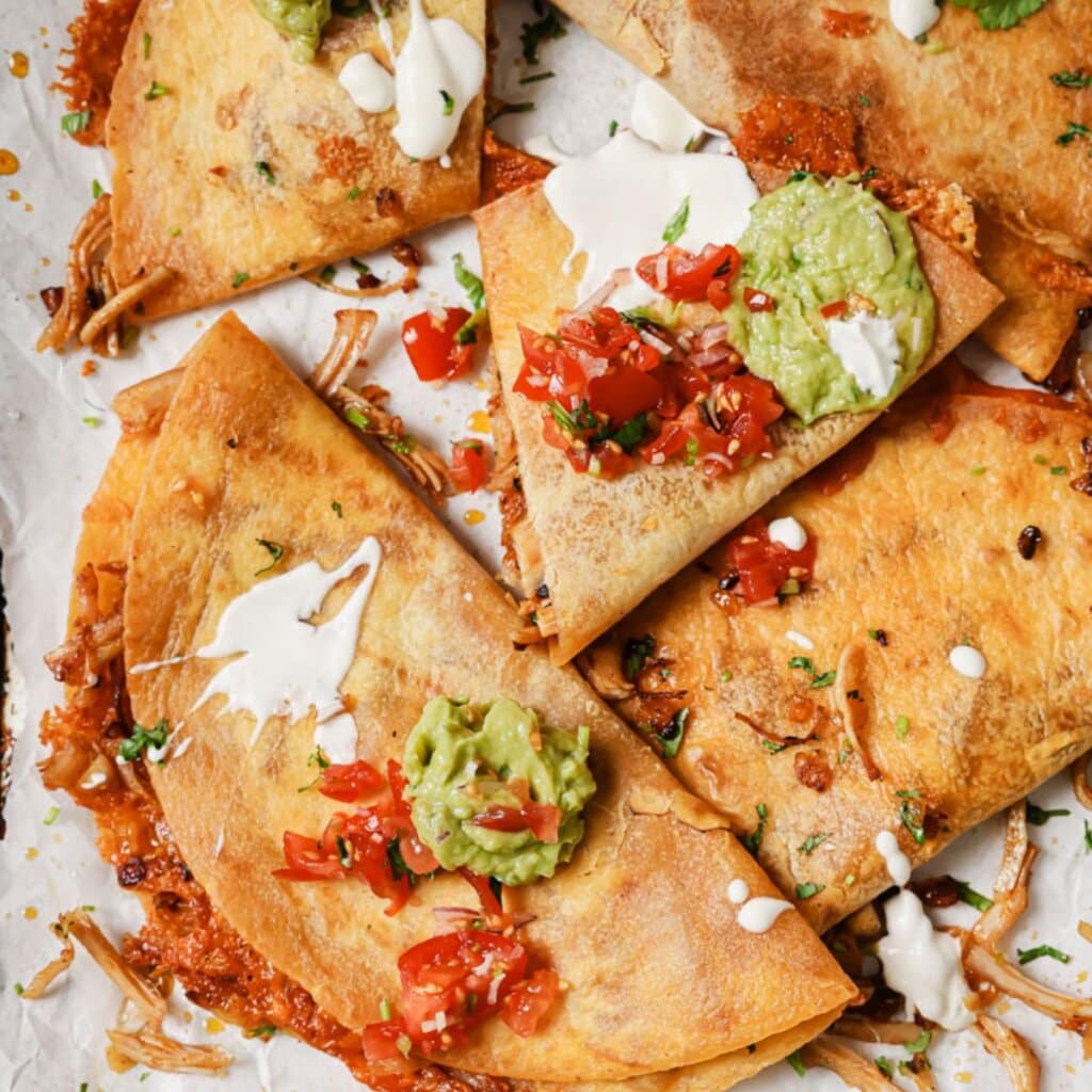 leftover turkey quesadillas with salsa and guacamole on top and a few dollops of sour cream.