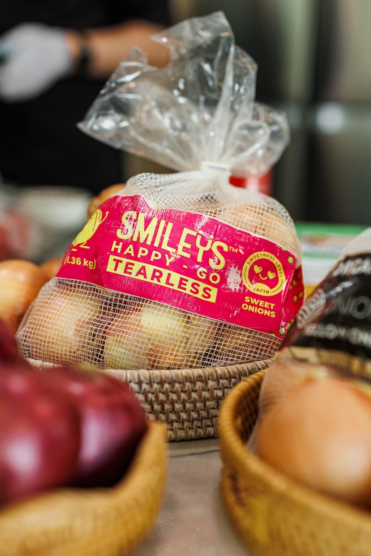 a bag of smileys onions with red onions to the side in a basket.