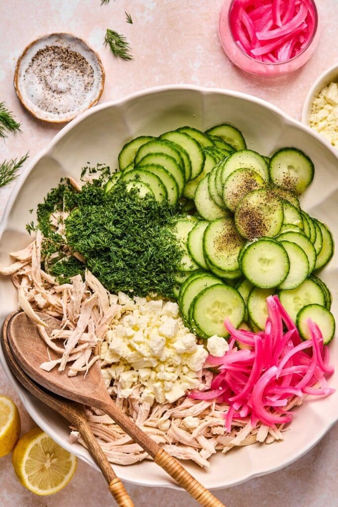 Ingredients for cucumber salad in a large mixing bowl.