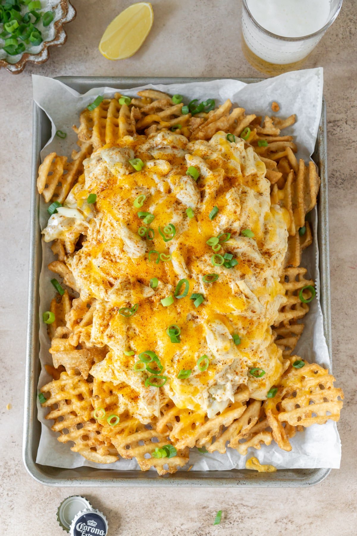 A tray filled with baked crab fries with melted cheese and scallions.