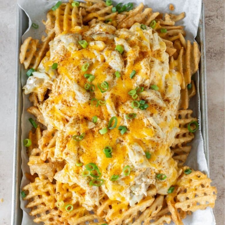 Crab fries on a baking sheet with melted cheese and scallions.